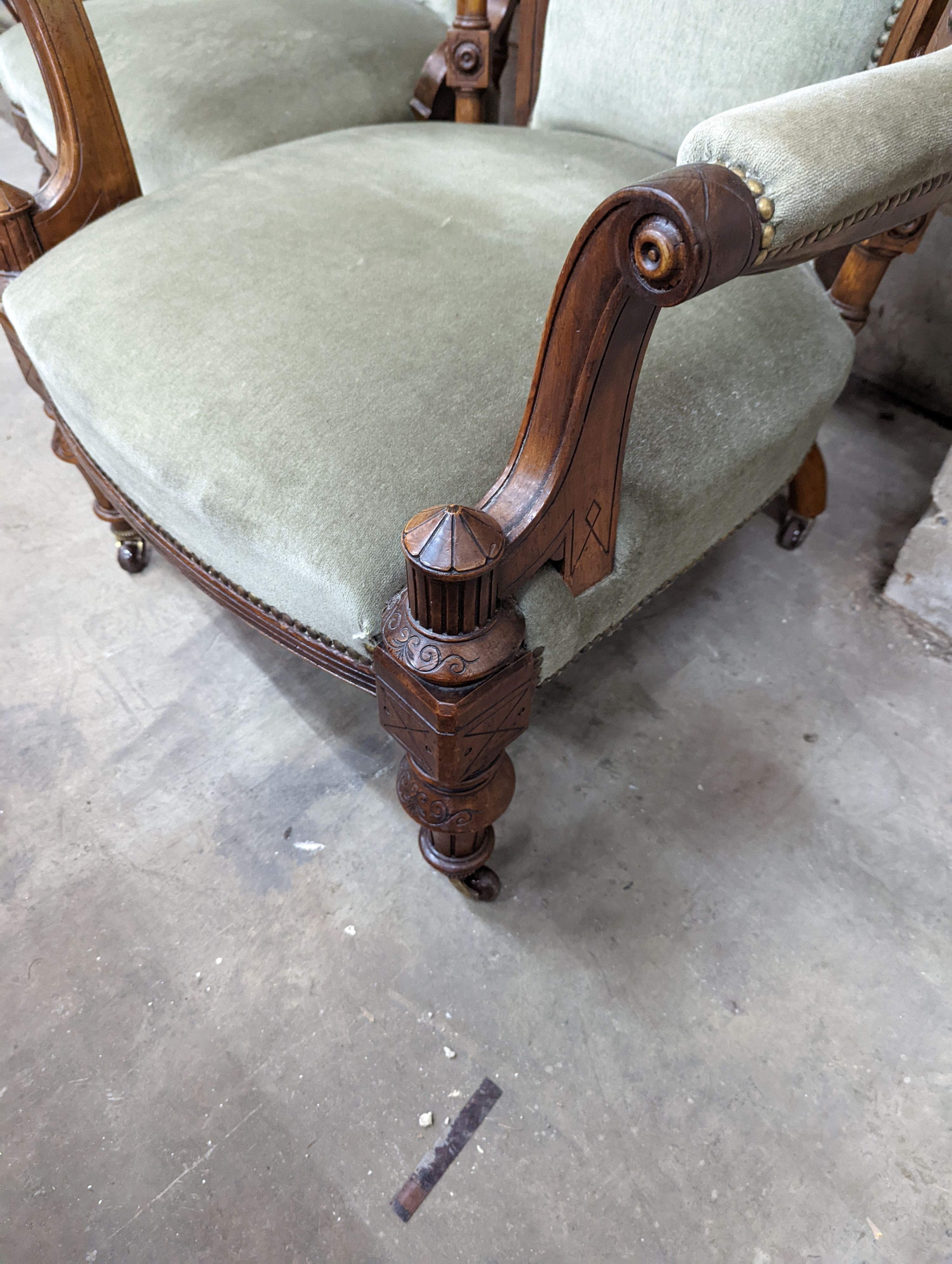 A pair of late Victorian carved walnut salon chairs upholstered in green dralon, one with arms